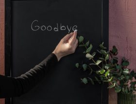 person writing on black board with chalk