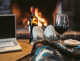 macbook pro beside wine glass on brown wooden table
