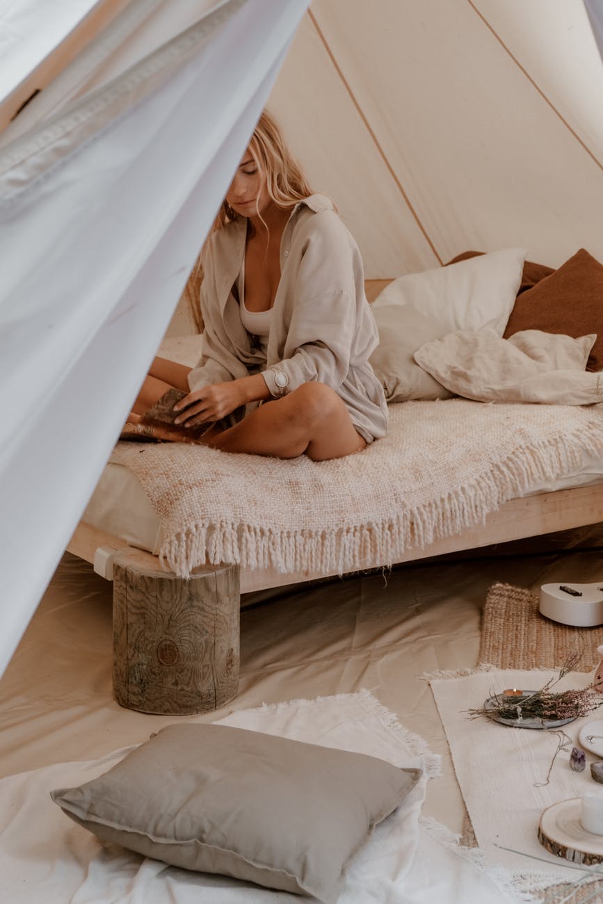 woman in white robe sitting on bed