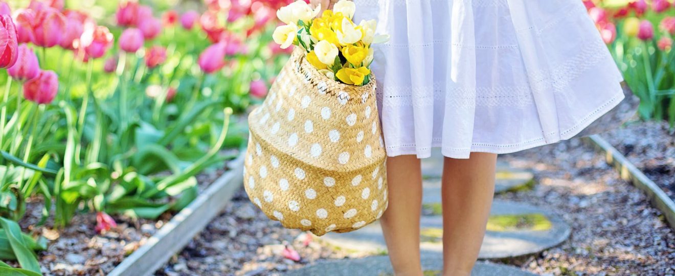 woman holding brown basket with yellow flowers