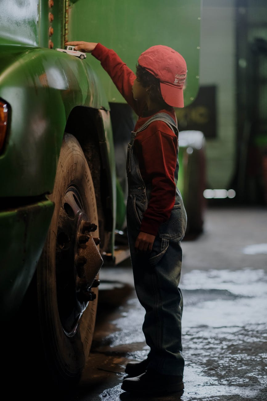 a boy in standing beside the car